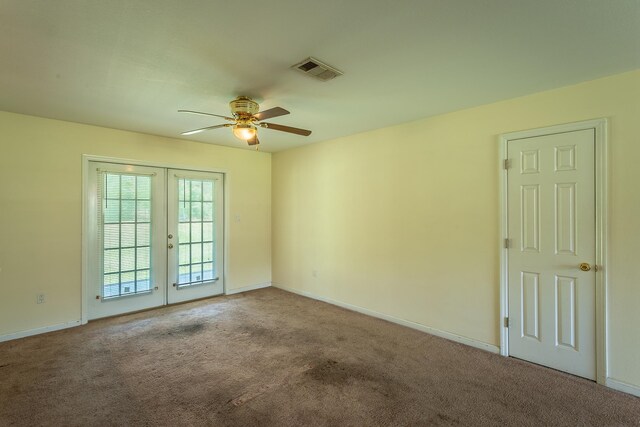 empty room with french doors, ceiling fan, and carpet