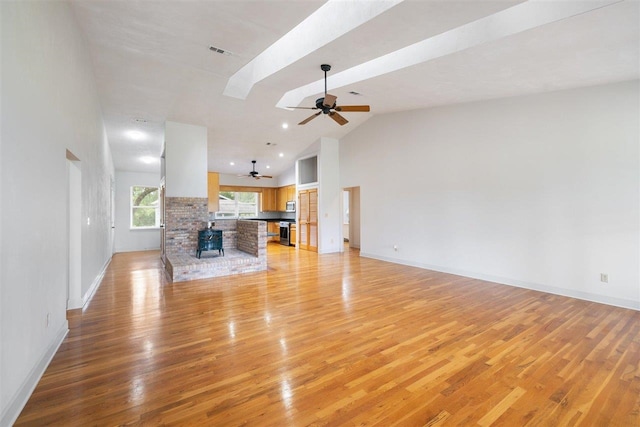 unfurnished living room featuring light hardwood / wood-style floors, high vaulted ceiling, and ceiling fan