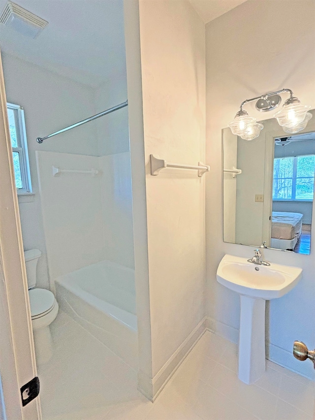 bathroom with a shower, tile patterned flooring, toilet, and sink