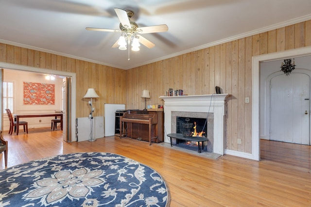 living room featuring hardwood / wood-style floors, ceiling fan, and ornamental molding