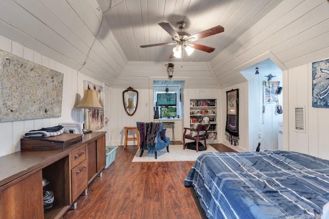 bedroom with ceiling fan, wood walls, dark wood-type flooring, and vaulted ceiling