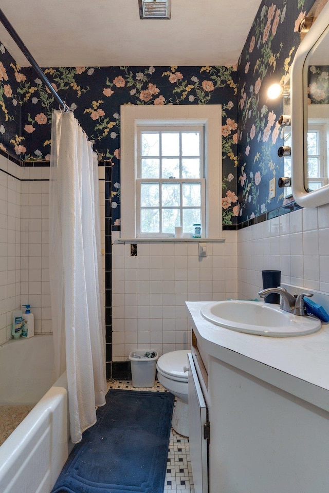 full bathroom with vanity, tile patterned floors, toilet, shower / bath combo with shower curtain, and tile walls