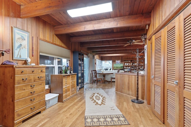 interior space featuring beamed ceiling, wood ceiling, wooden walls, and light hardwood / wood-style flooring