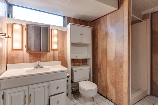 bathroom with vanity, wooden walls, a shower, tile patterned flooring, and toilet