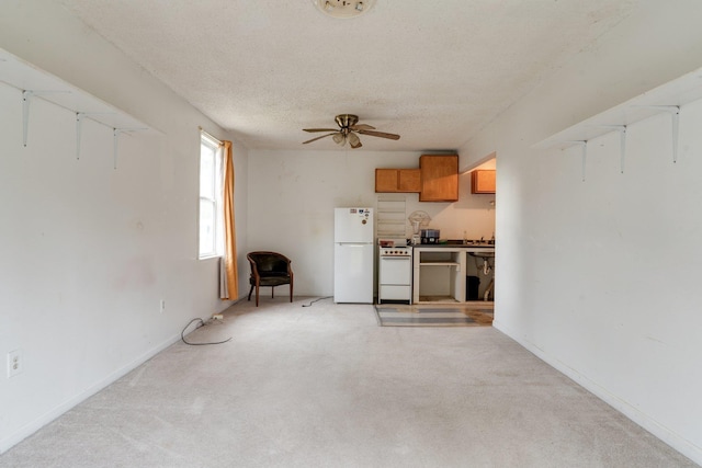 unfurnished living room with ceiling fan, a textured ceiling, and light carpet