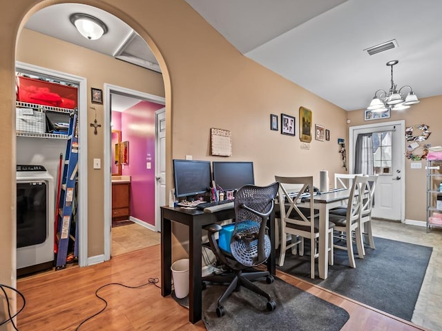 office with hardwood / wood-style floors, washer / clothes dryer, and a chandelier