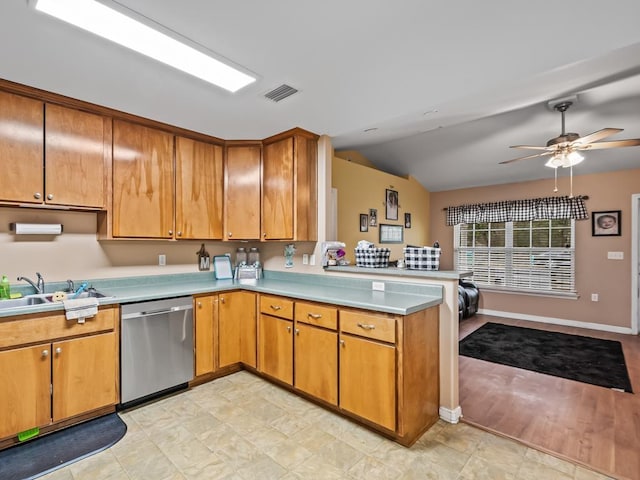 kitchen featuring ceiling fan, dishwasher, sink, kitchen peninsula, and vaulted ceiling