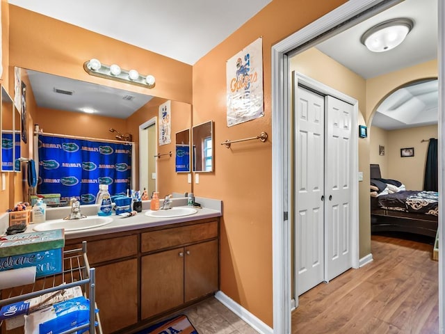 bathroom featuring wood-type flooring, vanity, and walk in shower