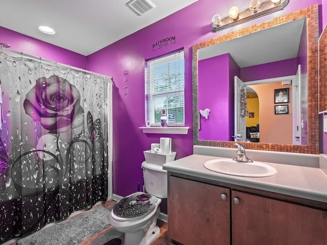 bathroom with vanity, a shower with shower curtain, and toilet