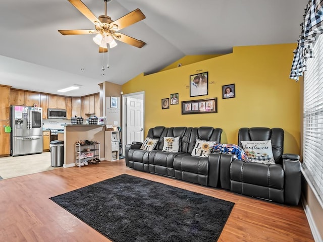 living room with ceiling fan, light wood-type flooring, and lofted ceiling