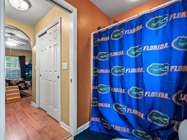 bathroom with ceiling fan, hardwood / wood-style floors, and a shower with shower curtain