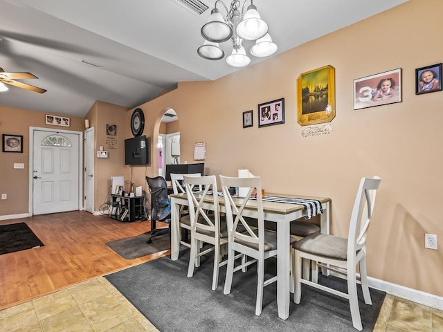 dining area with lofted ceiling, ceiling fan with notable chandelier, and hardwood / wood-style flooring