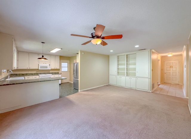 unfurnished living room with light carpet, a textured ceiling, a sink, and recessed lighting