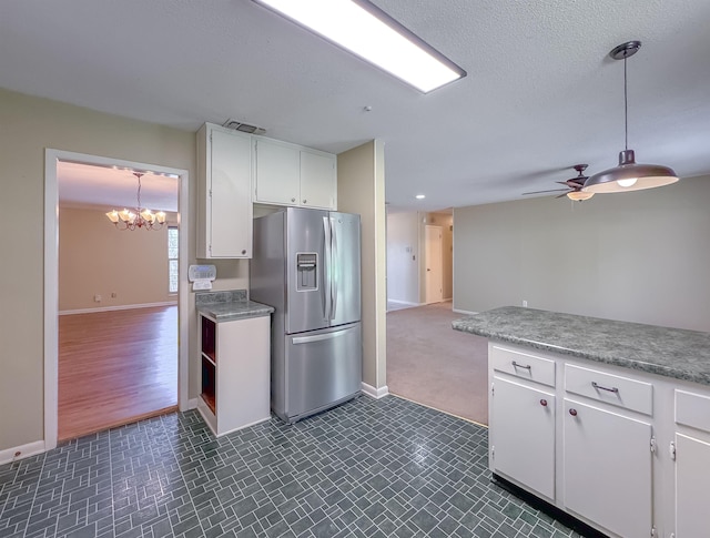 kitchen featuring ceiling fan with notable chandelier, visible vents, white cabinetry, light countertops, and stainless steel fridge