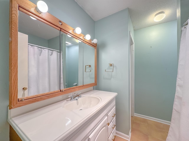 full bath with tile patterned floors, baseboards, a textured ceiling, and vanity