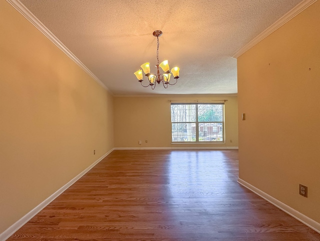 empty room featuring crown molding, a textured ceiling, a chandelier, and wood finished floors