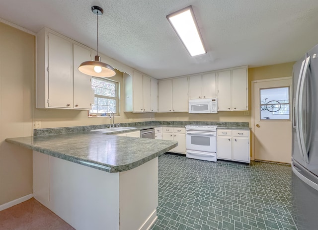 kitchen with white cabinets, a peninsula, hanging light fixtures, stainless steel appliances, and a sink