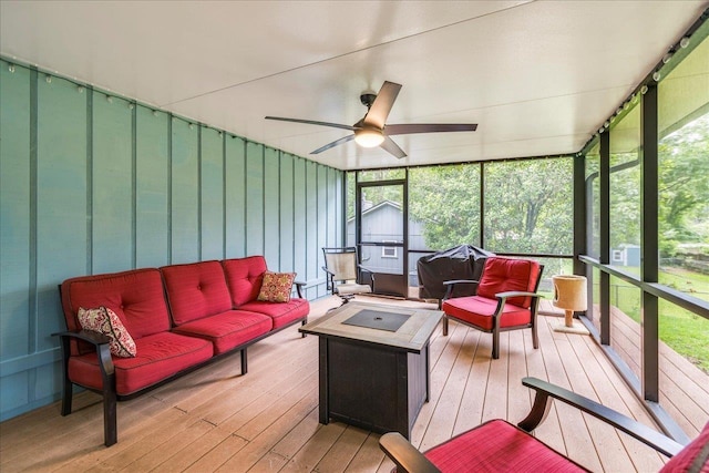 sunroom with an outdoor living space with a fire pit, ceiling fan, and healthy amount of natural light