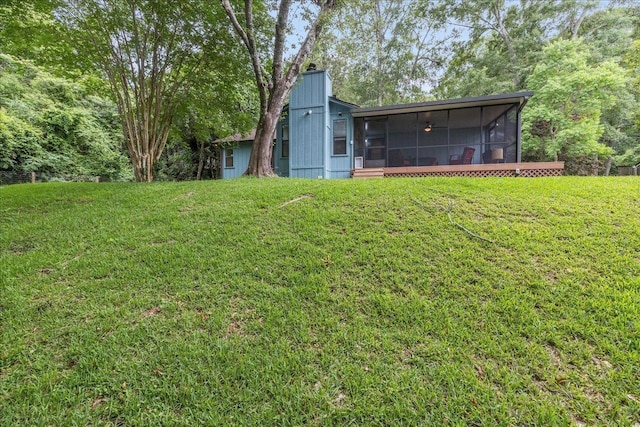 rear view of property with a sunroom and a lawn