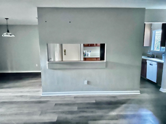 kitchen with pendant lighting, white appliances, sink, and hardwood / wood-style floors