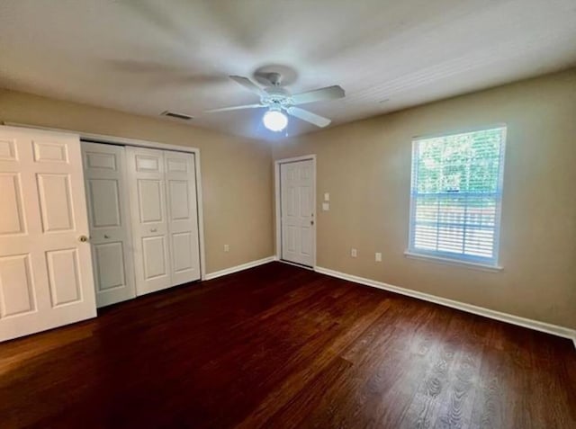 unfurnished bedroom featuring ceiling fan and dark hardwood / wood-style flooring