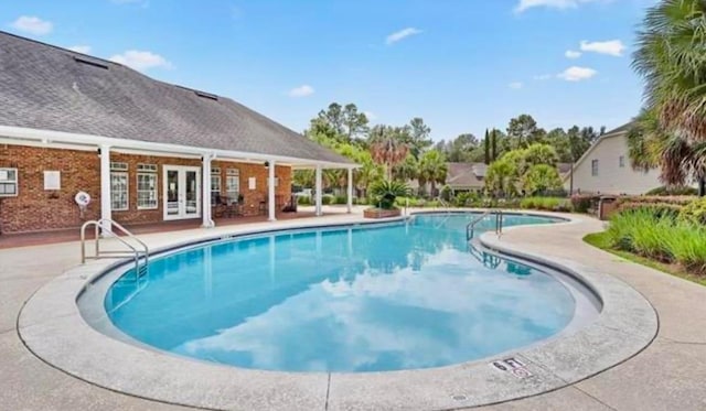 view of pool featuring a patio and french doors