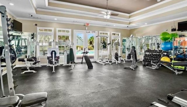 workout area with ceiling fan, french doors, a raised ceiling, and ornamental molding