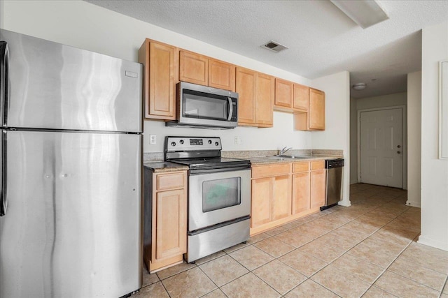 3000 S Adams St Unit 113, Tallahassee, FL 32301 - kitchen featuring stainless steel appliances, a sink, light tile patterned flooring, light countertops, and a textured ceiling