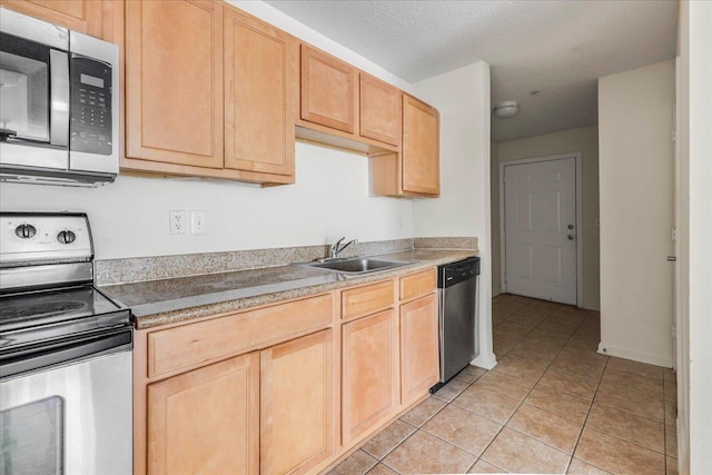 3000 S Adams St Unit 113, Tallahassee, FL 32301 - kitchen with appliances with stainless steel finishes, a sink, light tile patterned flooring, light brown cabinetry, and light countertops