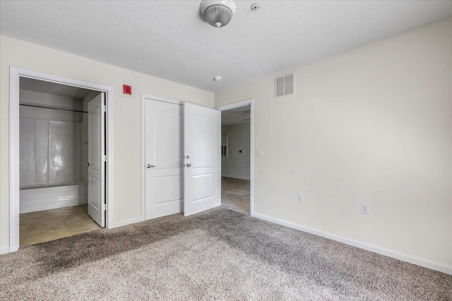 3000 S Adams St Unit 113, Tallahassee, FL 32301 - unfurnished bedroom with carpet, baseboards, connected bathroom, and a textured ceiling