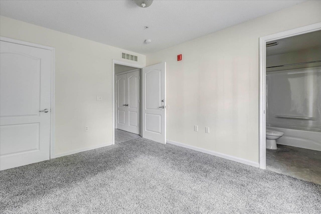 3000 S Adams St Unit 113, Tallahassee, FL 32301 - unfurnished bedroom with carpet flooring, baseboards, and ensuite bath