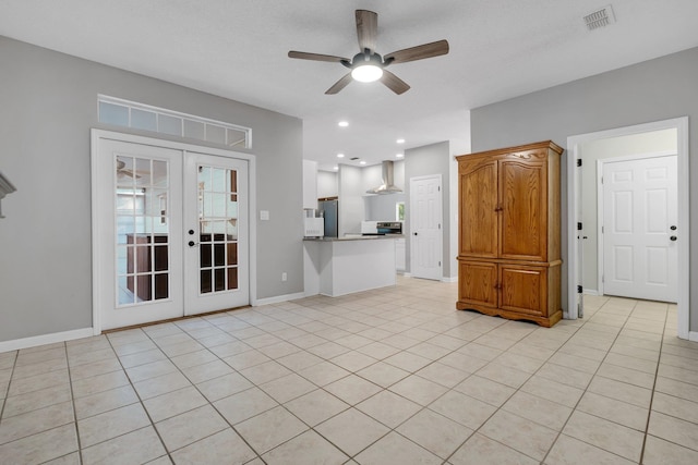 unfurnished living room with light tile patterned floors, a textured ceiling, ceiling fan, and french doors