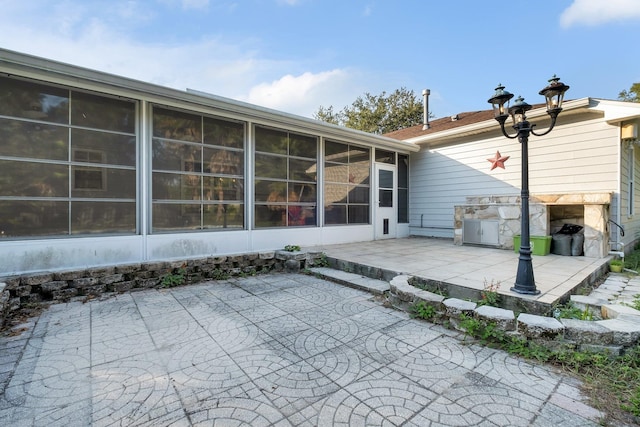 rear view of property with a sunroom and a patio