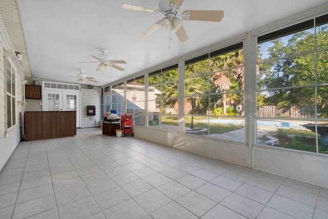 unfurnished sunroom featuring a healthy amount of sunlight and ceiling fan