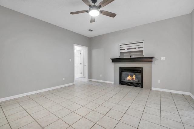 unfurnished living room featuring a tile fireplace and ceiling fan