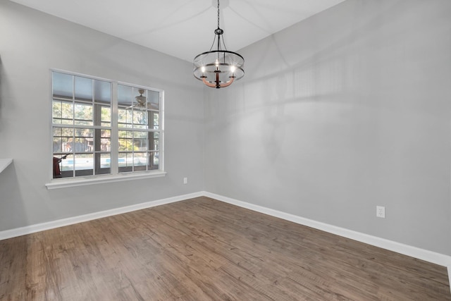 unfurnished dining area featuring hardwood / wood-style flooring and an inviting chandelier