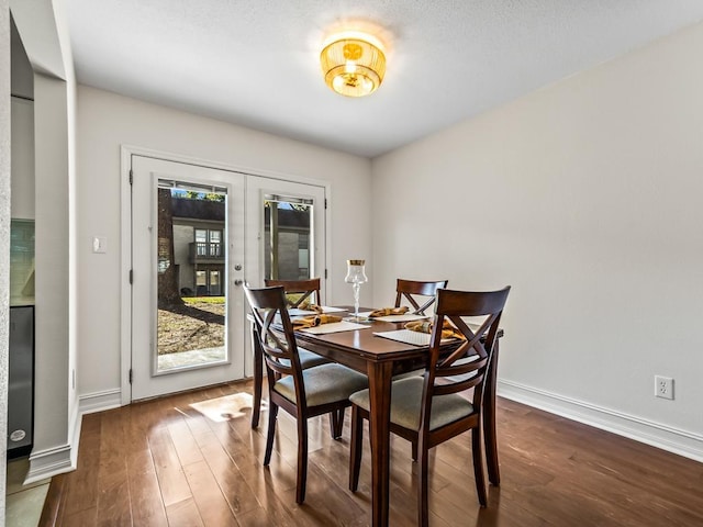 dining space with dark hardwood / wood-style floors and french doors