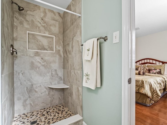 bathroom featuring wood-type flooring and tiled shower