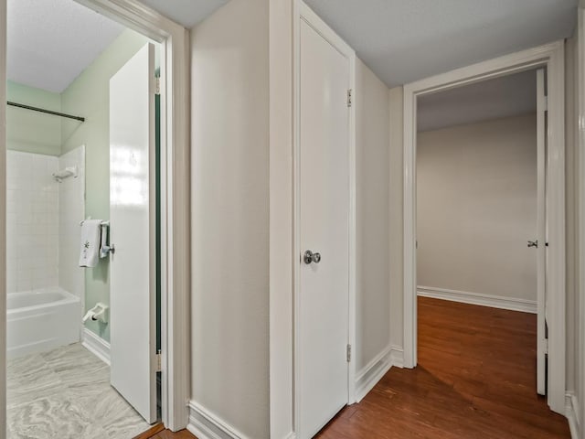 corridor with hardwood / wood-style floors