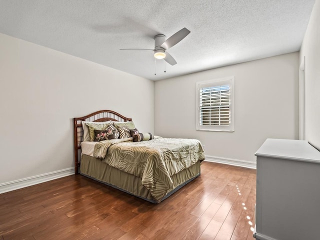 bedroom with ceiling fan, dark hardwood / wood-style floors, and a textured ceiling