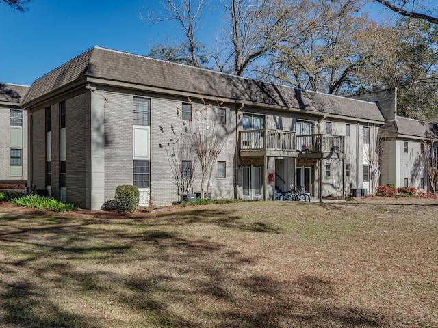 rear view of house featuring a yard