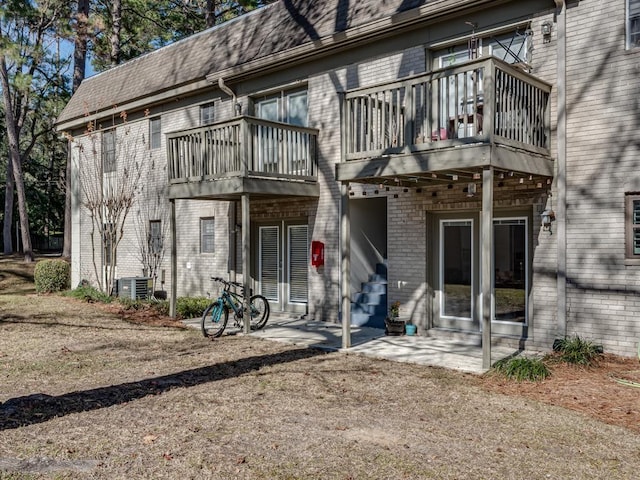 rear view of property with central air condition unit and a patio area