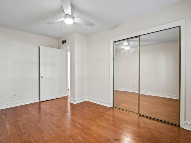 unfurnished bedroom featuring ceiling fan, a closet, and hardwood / wood-style floors