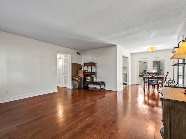 living room featuring dark wood-type flooring and a textured ceiling