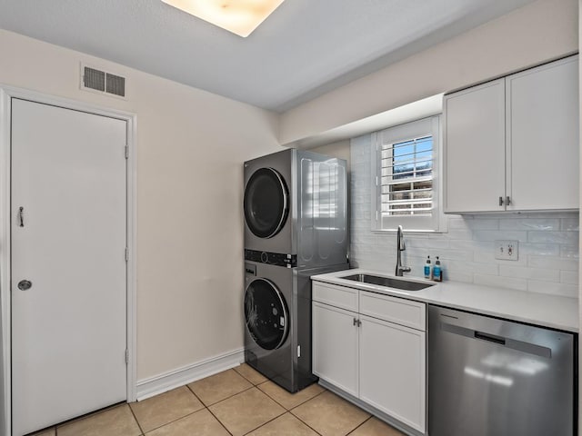 washroom with sink, stacked washer and clothes dryer, and light tile patterned flooring