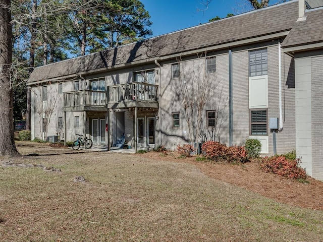 back of property featuring cooling unit and a yard