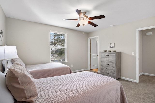 bedroom featuring baseboards, light colored carpet, and a ceiling fan