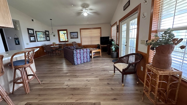 living room with lofted ceiling, hardwood / wood-style floors, ceiling fan, and french doors