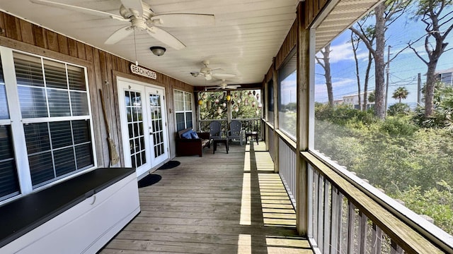 unfurnished sunroom featuring ceiling fan