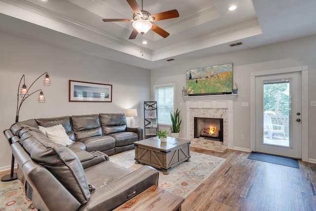 3524 Rosemont Ridge Rd, Tallahassee, FL 32312 - living room featuring light wood-style floors, ornamental molding, a ceiling fan, a tray ceiling, and a fireplace